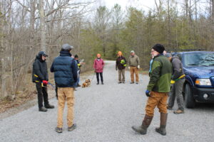 KLT staff, intern, and volunteers in a circle in Heber Rogers Wildlife Area parking area before trail blazing