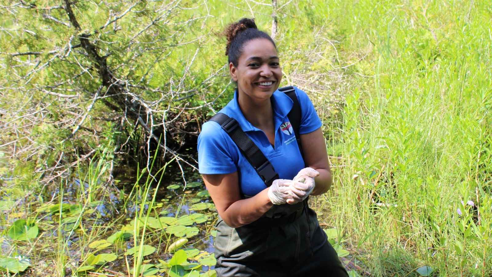 Patricia Wilson holding a Map Turtle Hatchling before releasing it