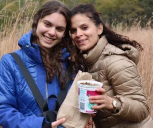 Two volunteers holding a bucket of tallgrass seeds at Ballyduff Trails
