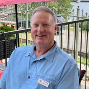 Eric Howe posing for a photo, sitting at a table at KLT's 2023 AGM.