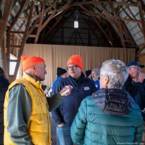 Two volunteers chatting with John Kintare, Executive Director, at KLT's 2025 Thanks.Giving event.