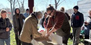 Cody processing seed with another KLT volunteer